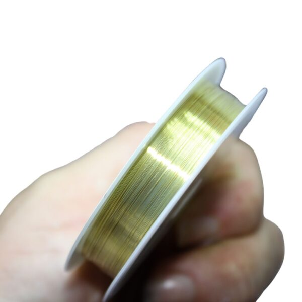 Close-up image of 0.3mm 15m gold-plated copper wire neatly coiled, showcasing its smooth, shiny finish and flexibility for jewelry making.