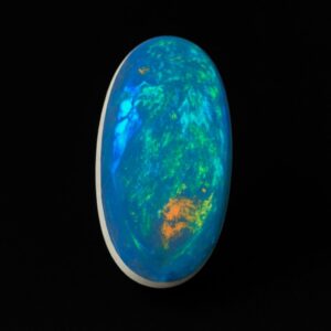 Image is of a boulder opal doublet with rainbow hues of colours