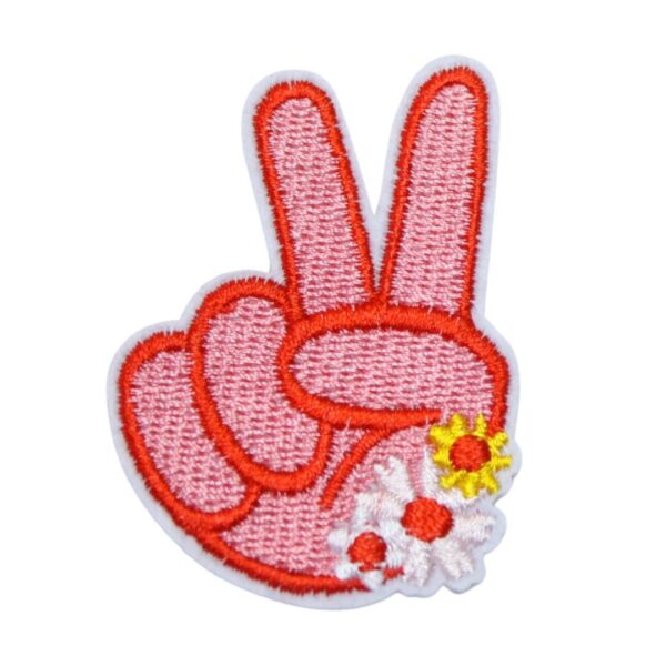 An embroidered pink peace sign iron-on patch, perfect for personalizing clothing, bags, and accessories. Easy to apply with heat, adding a retro touch to any project.