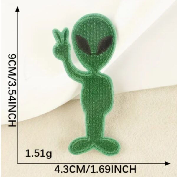 A Alien embroided iron on patch, perfect for personalizing clothing, bags, and accessories. Easy to apply with heat, adding a retro touch to any project.